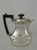 A Solid Silver Coffee Pot, on ball feet with ebony handle and finial, Birmingham hallmark, dated