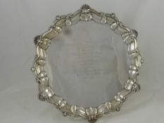 A Silver Presentation Salver, having a shell and laurel edge, on ball and claw feet, inscription