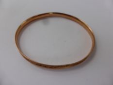 A Lady's 9ct Rose Gold Bangle, engraved with flowers, approx 10 gms.