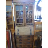 An Oak Arts & Crafts bureau book case with glazed cupboard, four drawers with copper hand made