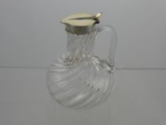 A Silver Topped Glass Water Jug, the jug having a thumb rest to the lid, Birmingham hallmark, m.m JG