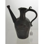 An Antique Bronze Ewer, with curved handle with decorative scroll and a straight spout, possibly