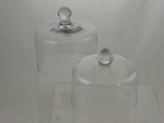 Two Glass Cake Covers, one approx 20 cms dia x 24 cms high, the other approx 17 dia x 20 cms high.
