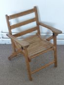 A Child's Wooden Folding Chair with slat seat together with two other pine children's chairs and a