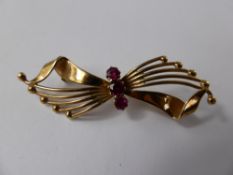 A Lady's 9ct Gold Brooch, in the form of a butterfly with three pink stones to the centre.