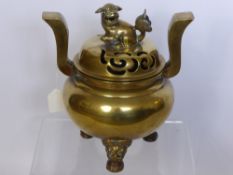 An Antique Brass Chinese Style Censer having a Dog of Fo finial with decorative tripod base and swan