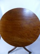 An Antique Mahogany Tilt Top Dining Table, on tripod base with brass castors.