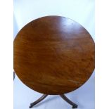 An Antique Mahogany Tilt Top Dining Table, on tripod base with brass castors.