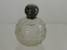 A Cut Glass Rounded Perfume Bottle with silver lid.