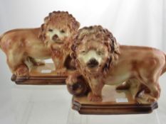 A Pair of High Glaze Ceramic Lions, depicted standing with foot raised, glass eyes, approx 30 x 31
