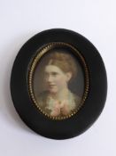 A Victorian Portrait Miniature of a pretty young woman, housed in an oval ebonised frame.