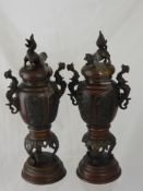 A Pair of Bronzed Composite Mantle Garniture Urns, with Fo Dog finials and sea serpent handles,