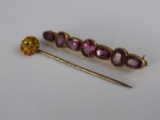 An Edwardian Gold Metal and Amethyst Pin Brooch, together with a 15 ct gentleman's tie pin. (2)
