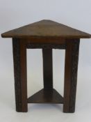 An Antique Oak Corner Table on straight legs with decorative carving depicting acorns.