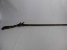 An Antique North African Flint Lock Musket, with Continental influence, checkered wrist and scroll