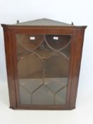 A Georgian Corner Cupboard, carved shelves and glazed front.