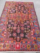 An Antique Turkish Style Woollen Carpet, geometric design in red/ochre/pink and blue, approx 150 x