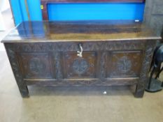 An Antique English Oak Chest with hand carved arcading to the top rail, decorative wheel and