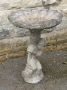 A Stone Composite Bird Bath, having a shell form pot with boy clutching a dolphin, approx 75 cms