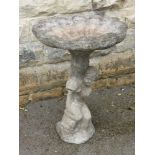 A Stone Composite Bird Bath, having a shell form pot with boy clutching a dolphin, approx 75 cms