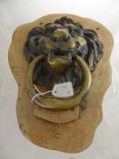 A Large Antique Brass Lion Head Door Knocker, mounted on an oak surround   approx 30 x 18 cms.