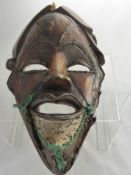 A Carved Wooden African Mask, with fine twisted wire decoration around the ears, eyes, brows and