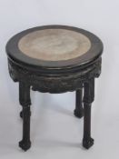 An Ebonised Oriental Style Occasional Table with Marble Inlaid Top, and floral carved skirt, four