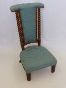 A Victorian Nursing Chair covered in blue fabric, barley twist front legs and back supports.