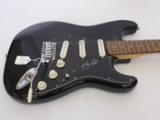 A Black Fender "Squier" Guitar signed by Eric Clapton.