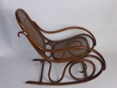 A Vintage Bentwood Rocking Chair with caned back and seat.