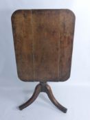 An Antique Oak Tilt-Top Table, the table having rectangular top on turned column and tripod  base,