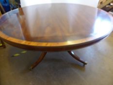 A Reproduction Mahogany and Yew Wood Inlay Circular Dining Table on four column base with brass