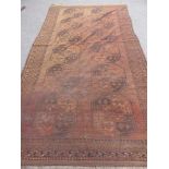 An Antique Bukhara Carpet having twelve medallions to centre, approx 350 x 190 cms together with