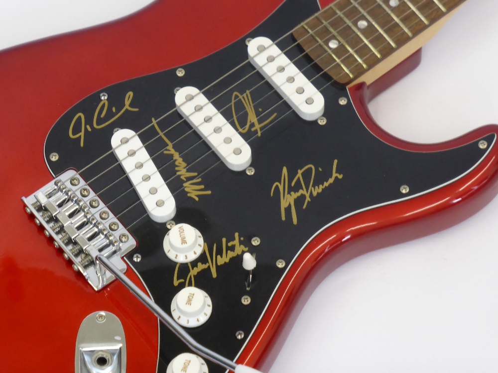 A Red Squier Fender Guitar signed by Maroon 5 Band Members, including Adam Levine, Jesse Carmichael,