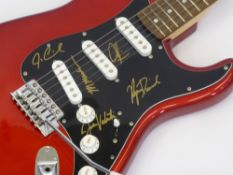 A Red Squier Fender Guitar signed by Maroon 5 Band Members, including Adam Levine, Jesse Carmichael,