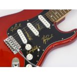 A Red Squier Fender Guitar signed by Maroon 5 Band Members, including Adam Levine, Jesse Carmichael,