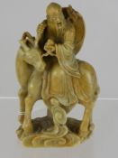 An Oriental Carved Soapstone Figure of a Wise Man on a stag. (WAF)