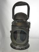 An Antique Train Signal Lantern, the lantern having green and red glass.