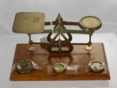 A Set of Brass and Oak Letter Scales, complete with weights.