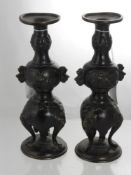 A Pair of Antique Japanese Bronzed Candle Sticks, the candle sticks having three lion mask feet,