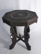 A South Asian Octagonal Occasional Table, the table with profuse decorative carving to top with a