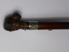 An Unusual Walking Cane, with knop carved as a grotesque face with inset glass eyes with silver