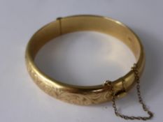 A Lady's 375 9 ct Gold Bangle, the bangle having floral decorations, approx wt 20 gms.