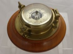An Oak Cased Ships Barometer, with brass case and dial.