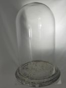 A Glass Display Dome on reconstituted stone base, approx 47 cms high.