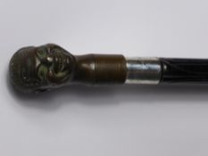 An Ebonised Walking Cane, with large bronze Negro's head (detachable, unscrews) with silver collar