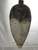 A Sub-Saharan African Tribal Mask, with a concave, heart shaped kaolin painted face, narrow slit