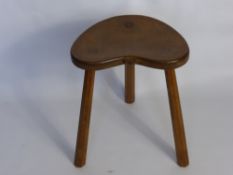 A Circa 1950 Robert Thompson "Mouseman Stool", the three legged stool having a kidney shaped seat.