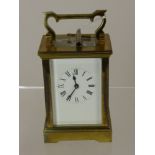 A Brass Carriage Clock with white enamel face and Roman dial, movement stamped A.C.G., approx 15 x 8