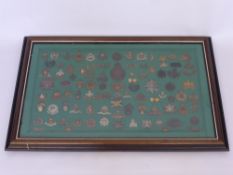 A Framed Display of Military Badges, approx 100 items, including Royal Flying Corps, Manchester Reg.